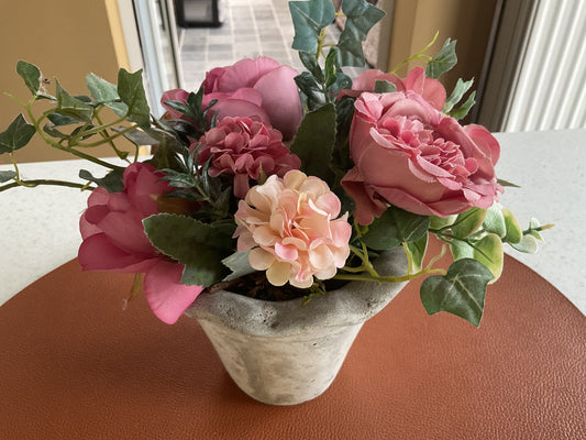 Betonnen bloempot met bloemen en groen